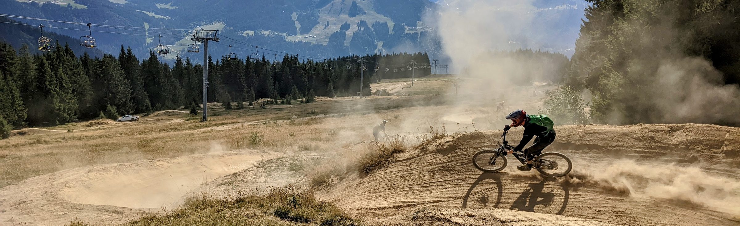 Mountain biker railing a dusty berm